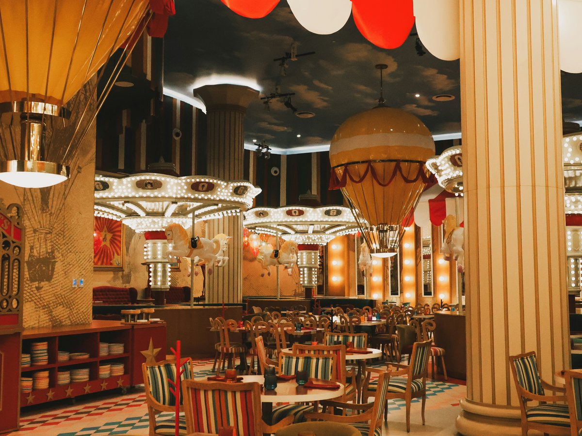 A restaurant with tables, chairs, and hot air balloons