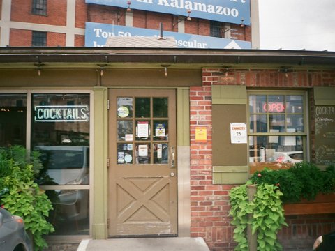 the front of a restaurant with a sign above the door