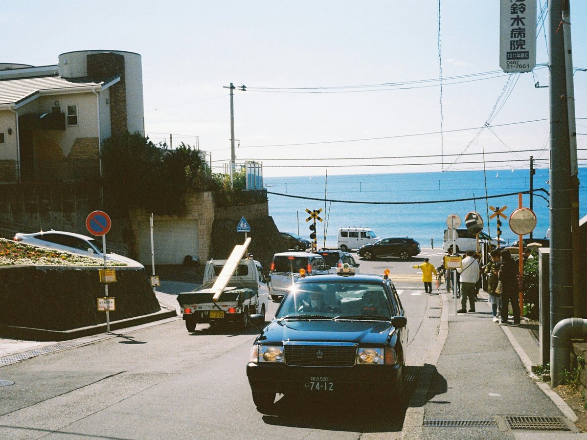 A coastal street scene with vehicles and people