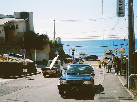 A coastal street scene with vehicles and people