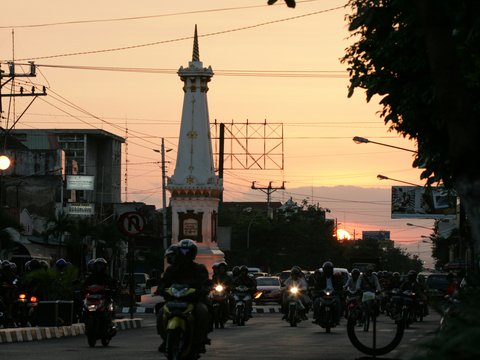 people riding motorcycle on road near white concrete building during daytime