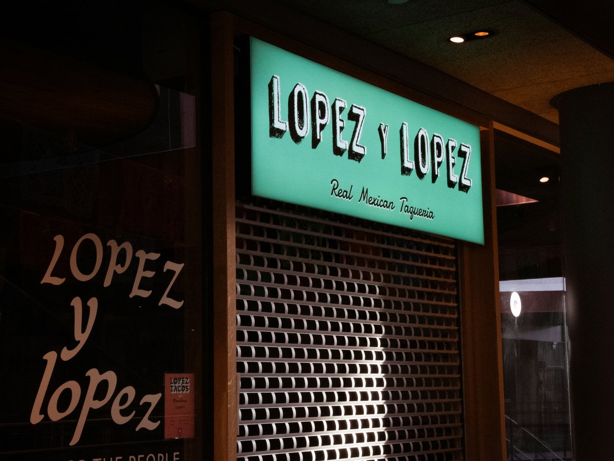 Lopez y lopez restaurant storefront at night with closed shutters