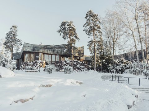 a house in the middle of a forest covered in snow