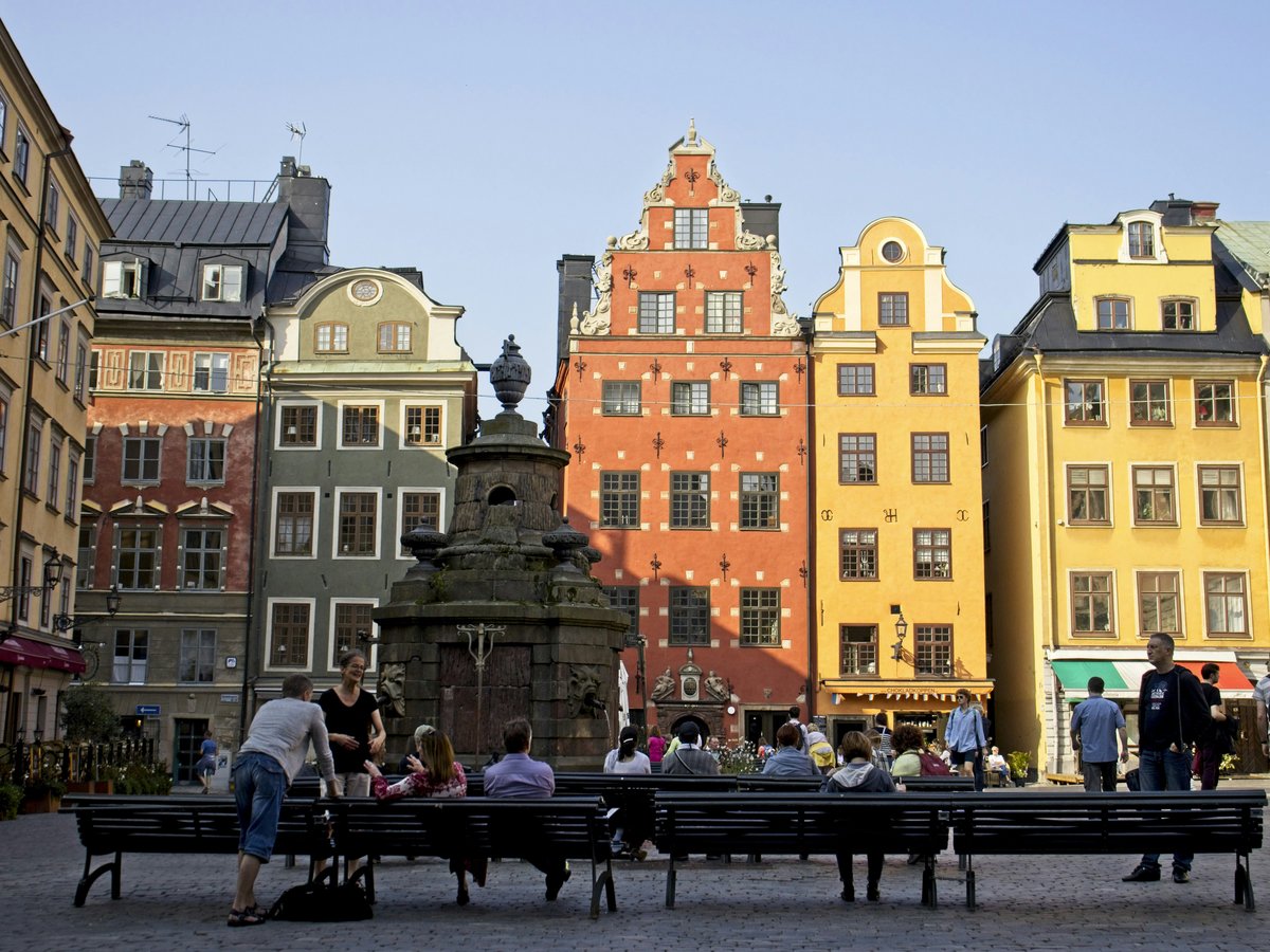 people sitting on bench near brown concrete building during daytime