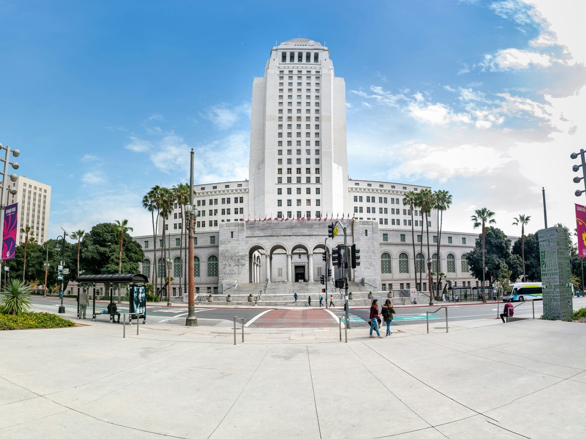 people walking on park near white concrete building during daytime