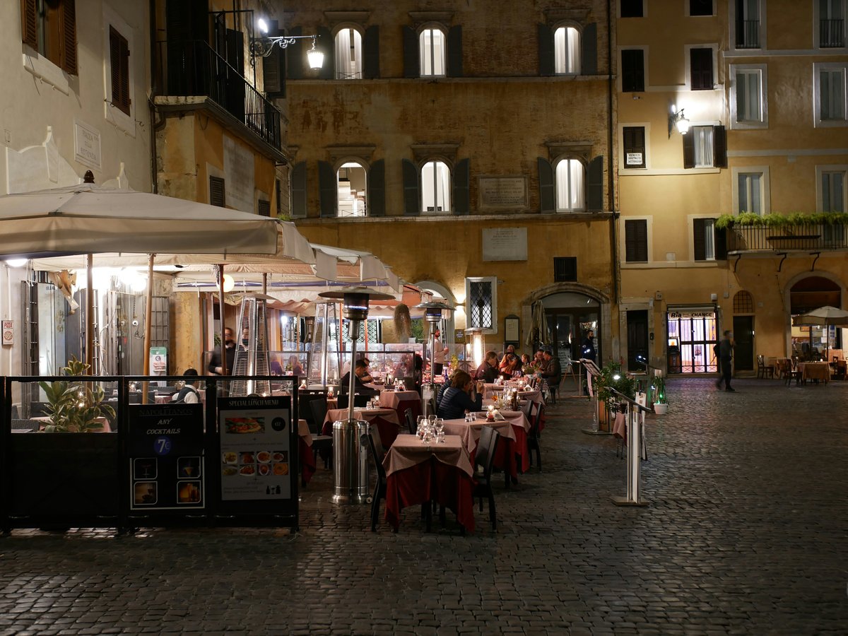 people sitting on chair near table and building during daytime