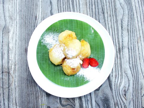 a plate of pastries with powdered sugar and raspberries