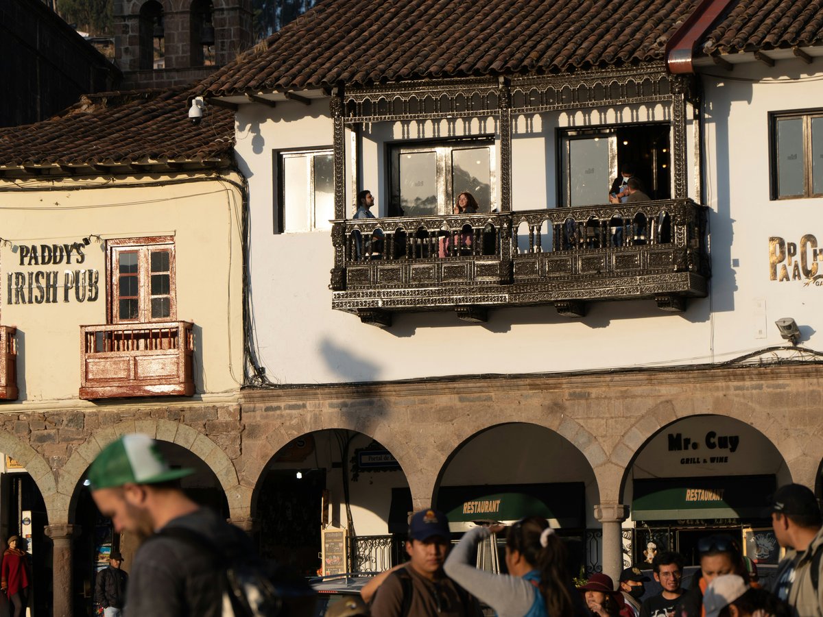 Buildings with balconies and people walking below.