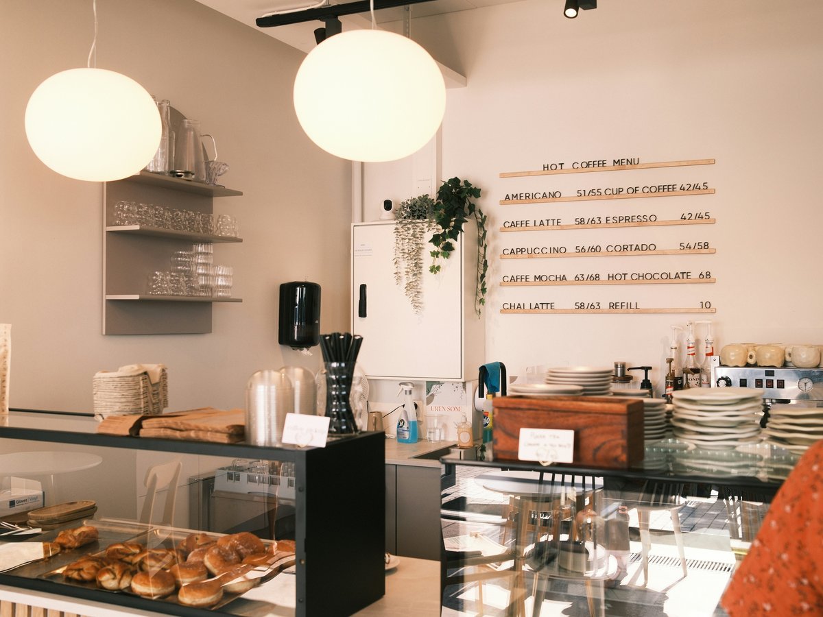 A woman standing in front of a counter filled with pastries