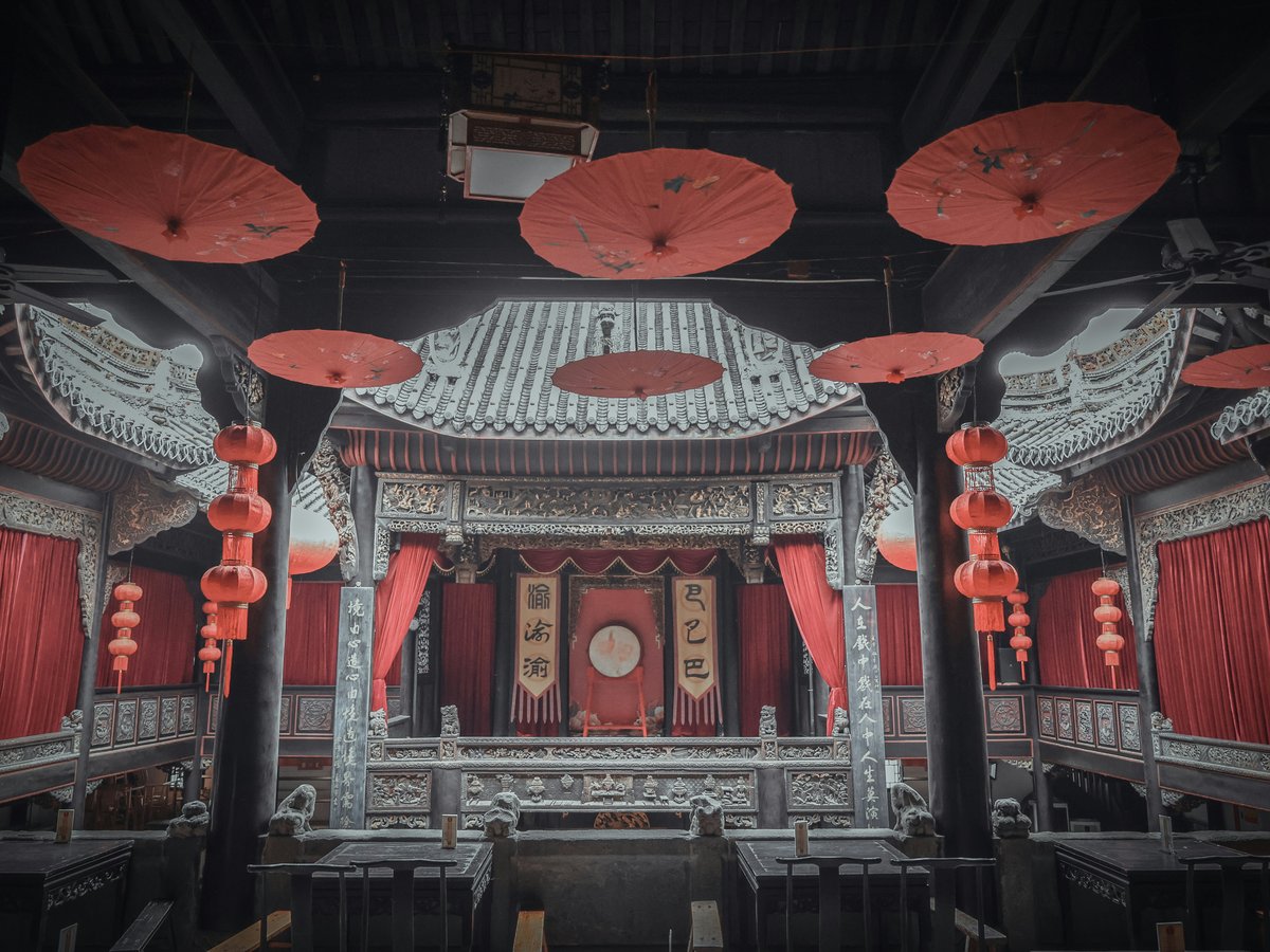 a building with red lanterns hanging from it's ceiling