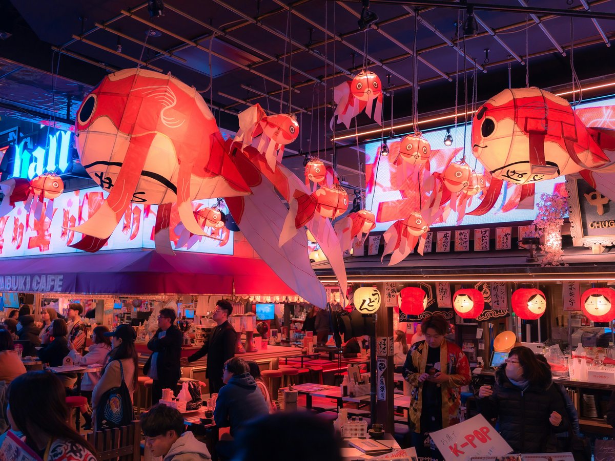 a group of people sitting at tables in a restaurant