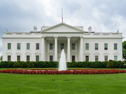 A large white building with a fountain in front of it