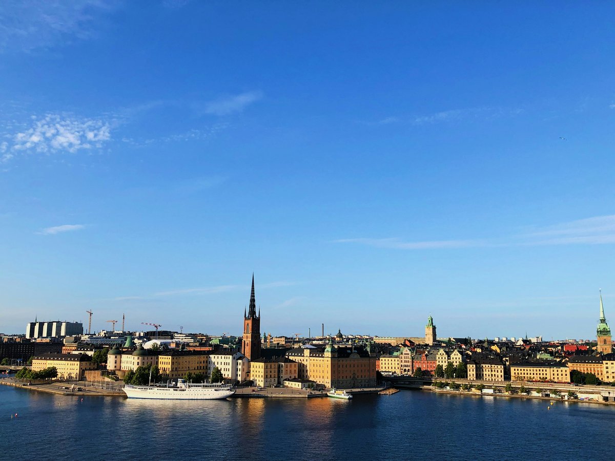 city buildings near body of water under blue sky