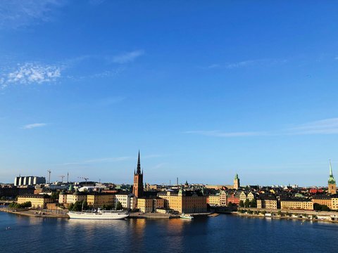 city buildings near body of water under blue sky