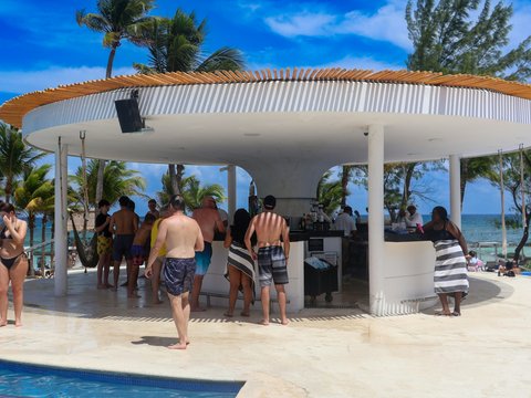 A group of people standing around a swimming pool