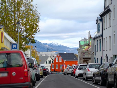 a street lined with parked cars next to tall buildings