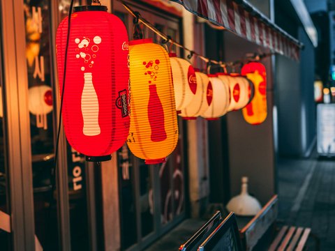 a row of red and yellow lanterns hanging from a building