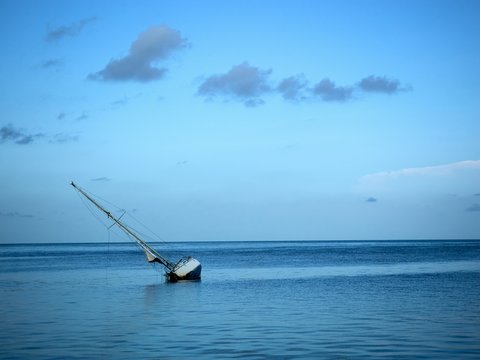 a sailboat sitting in the middle of the ocean