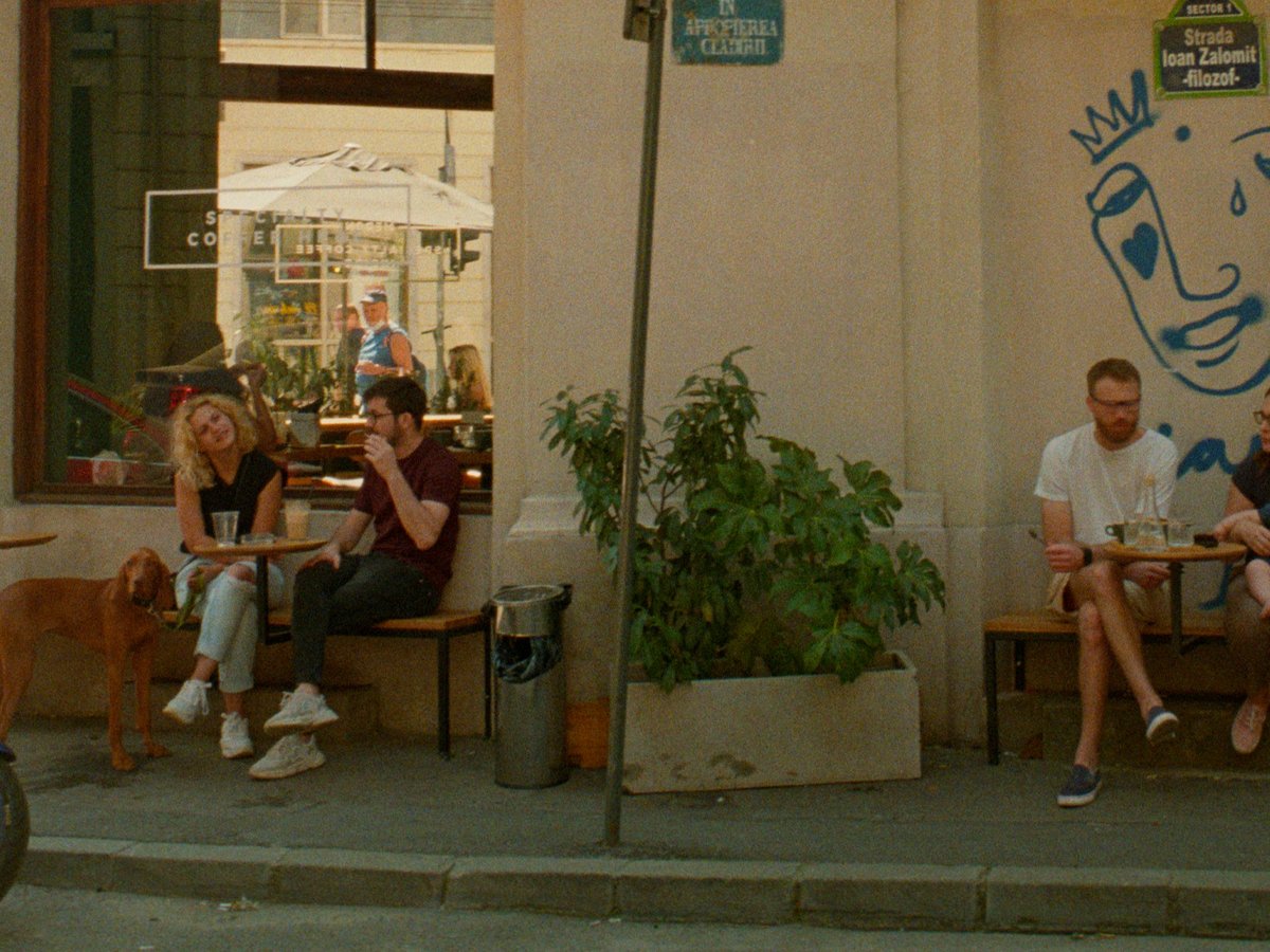 a group of people sitting outside of a restaurant
