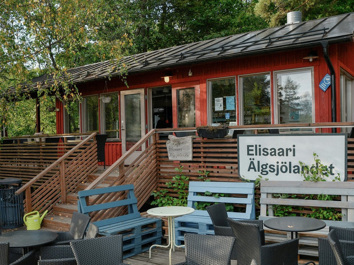 Red building with outdoor seating and a sign