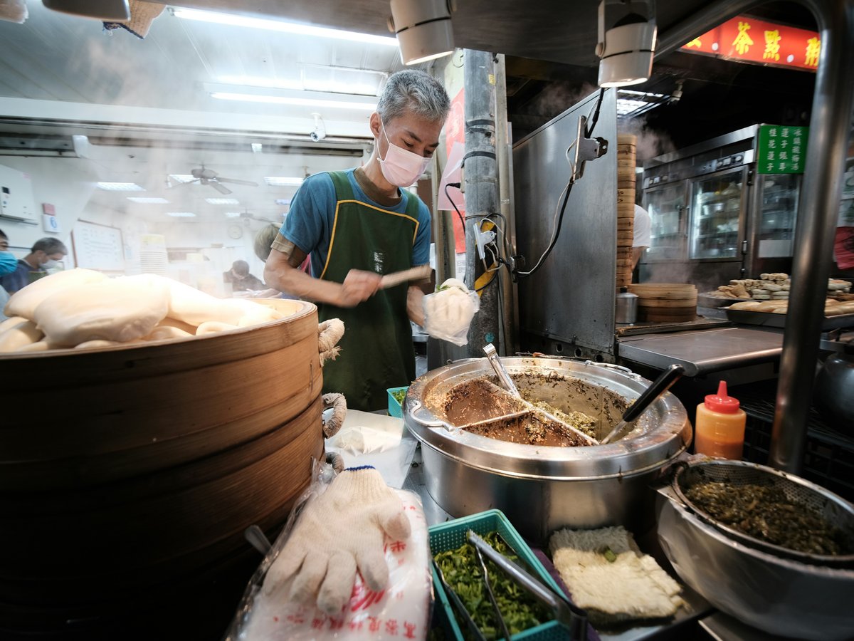 man in green apron cooking food