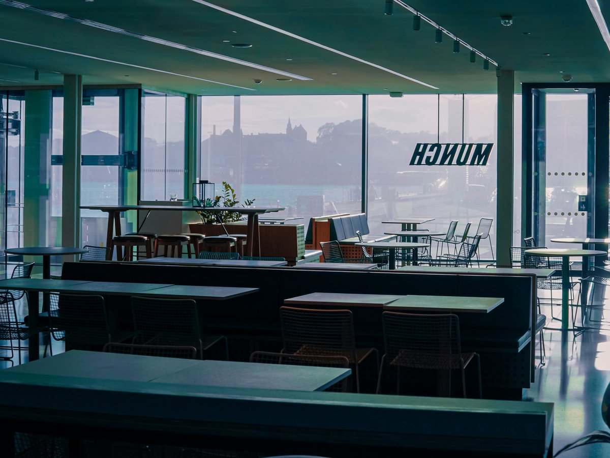 A large room with tables, chairs, and windows