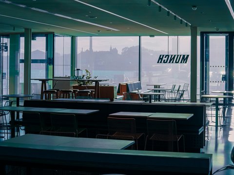 A large room with tables, chairs, and windows