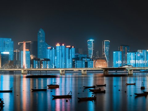 city skyline across body of water during night time