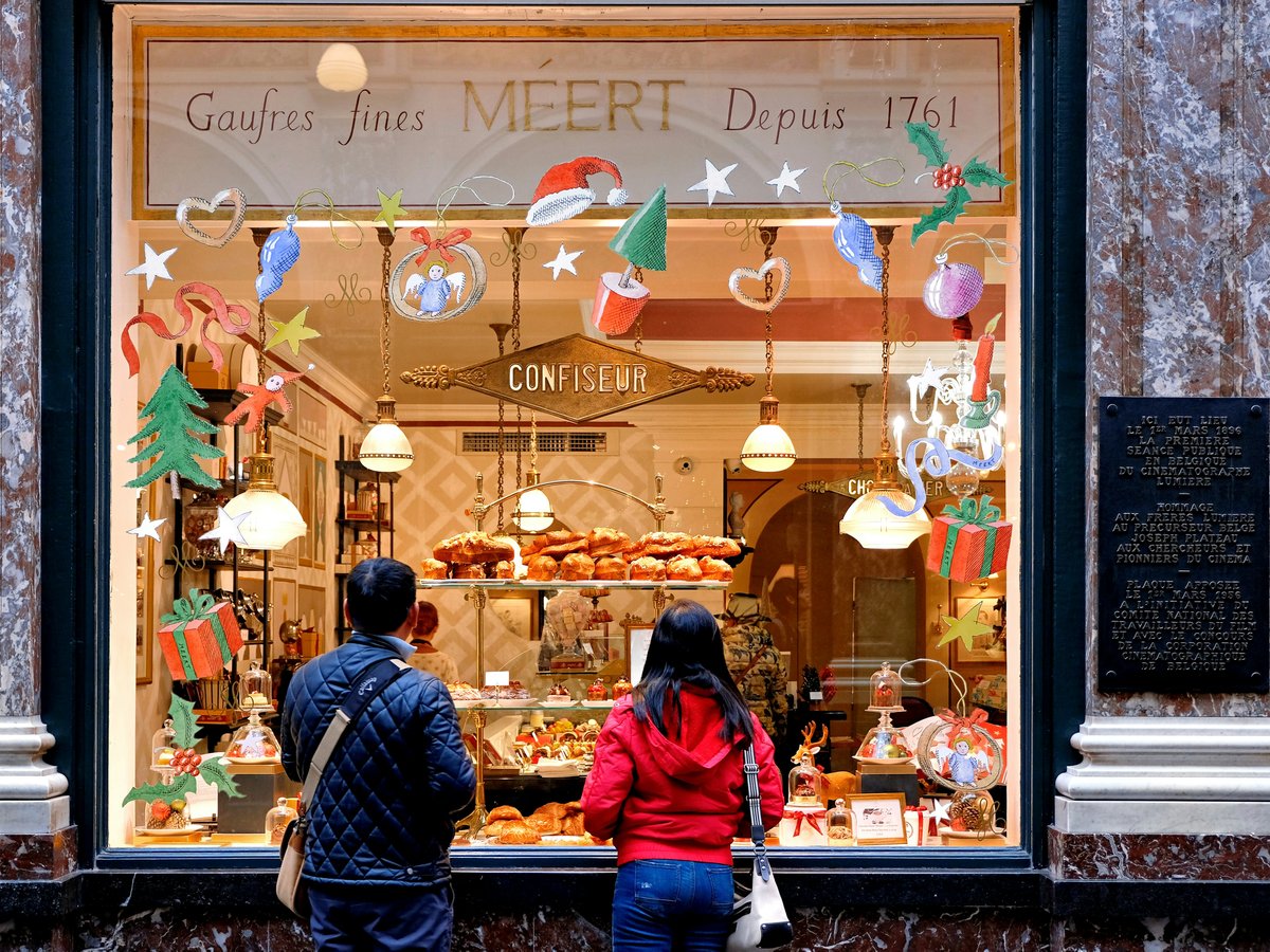 man in red jacket standing in front of store