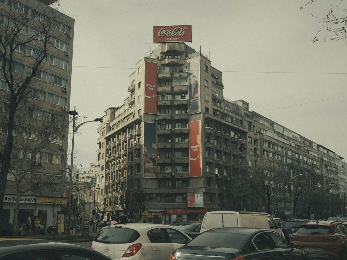 Urban street scene with tall buildings and cars.