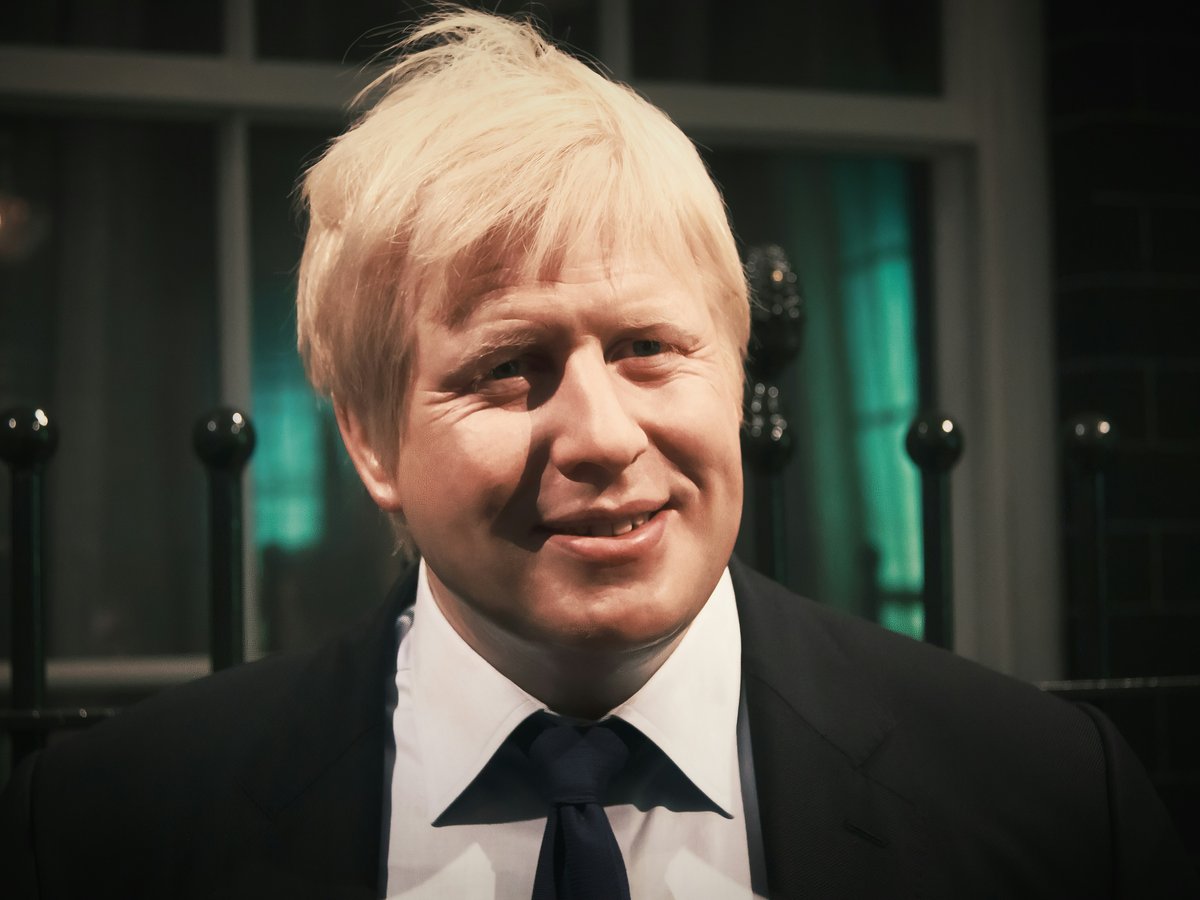 a close up of a person wearing a suit and tie