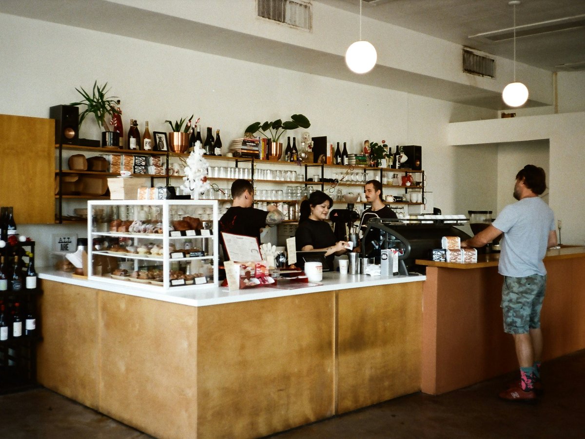 A man standing in front of a counter filled with bottles of wine