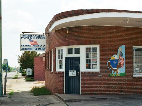 Brick building with american auto paint sign.