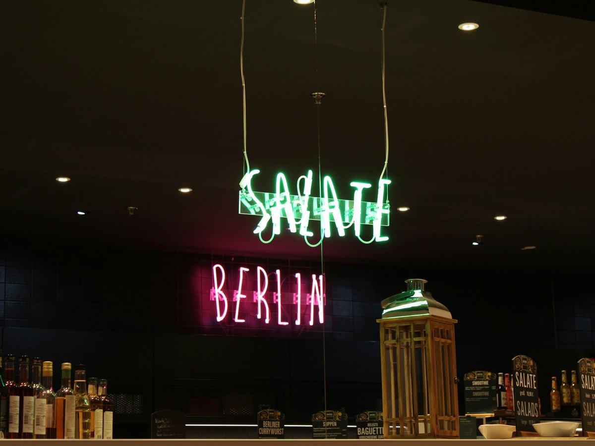 Neon signs for "salate" and "berlin" above bar