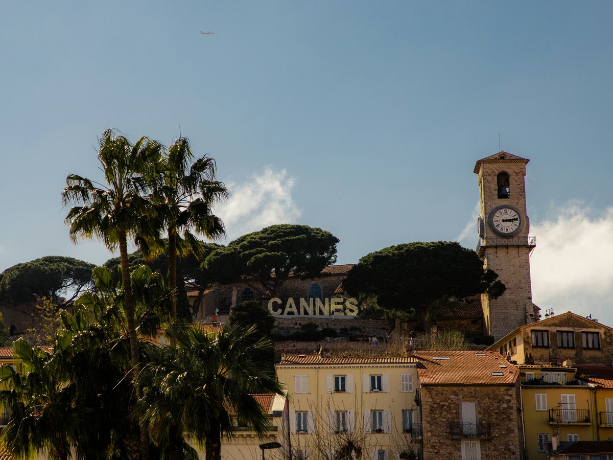 a clock tower on top of a building next to palm trees