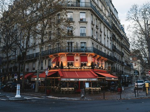 a building with a red awning in the middle of a street