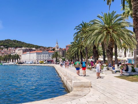 a group of people walking along a waterfront
