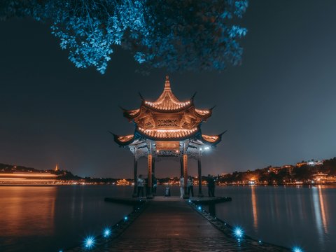 brown wooden gazebo near body of water during night time