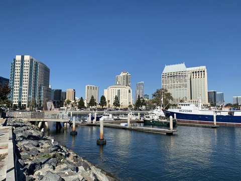 white and blue boat on sea near city buildings during daytime