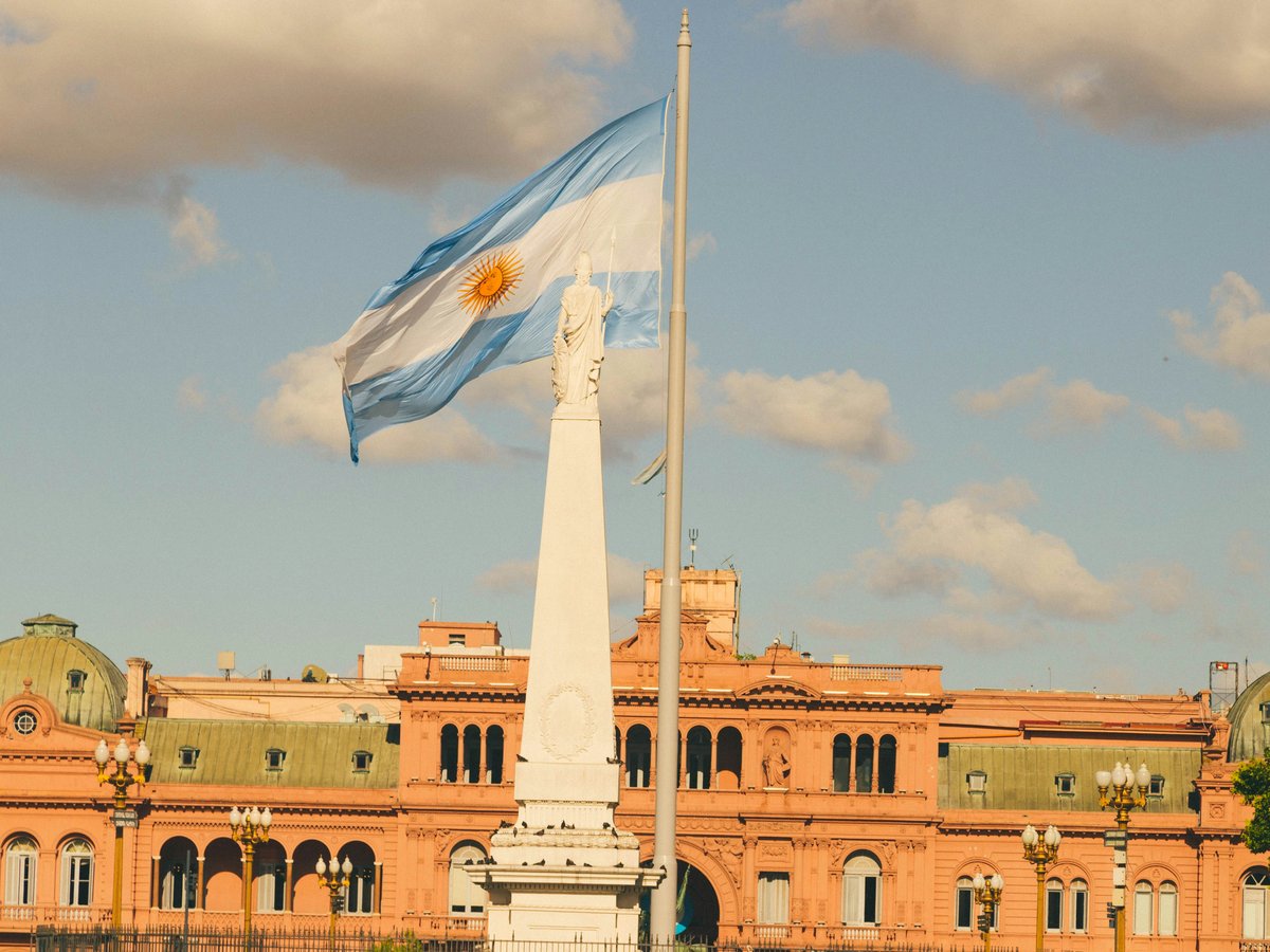 a flag flying in front of a large building