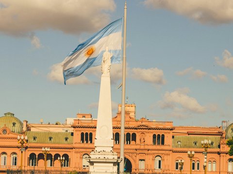 a flag flying in front of a large building