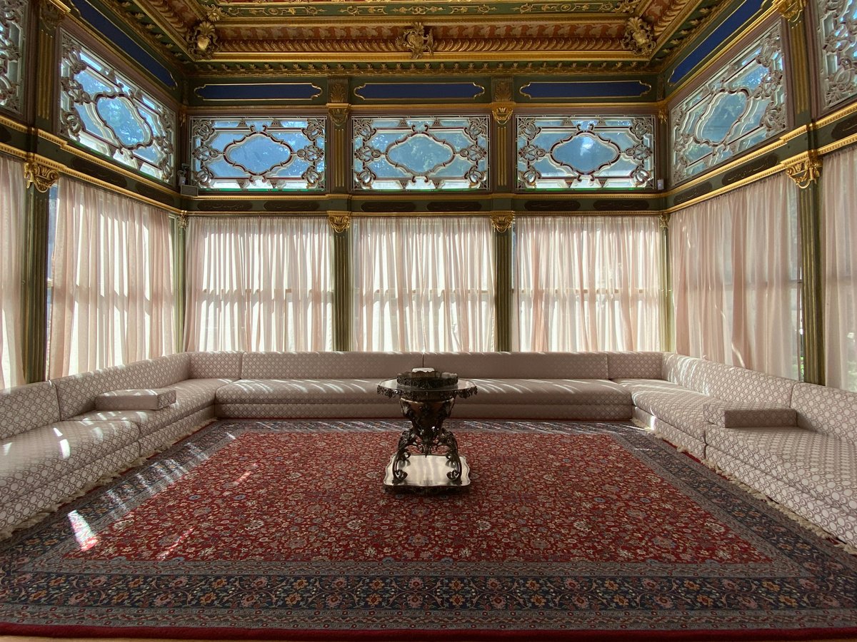 a room with a red carpet and a large chandelier