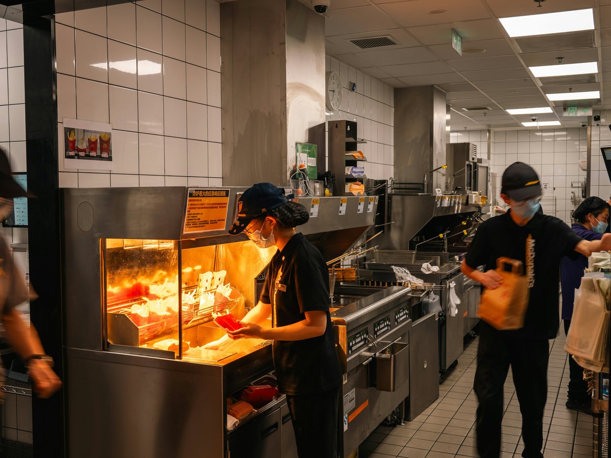 Workers preparing food in a busy restaurant kitchen