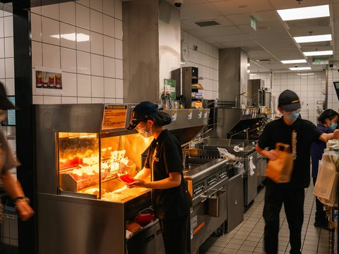 Workers preparing food in a busy restaurant kitchen