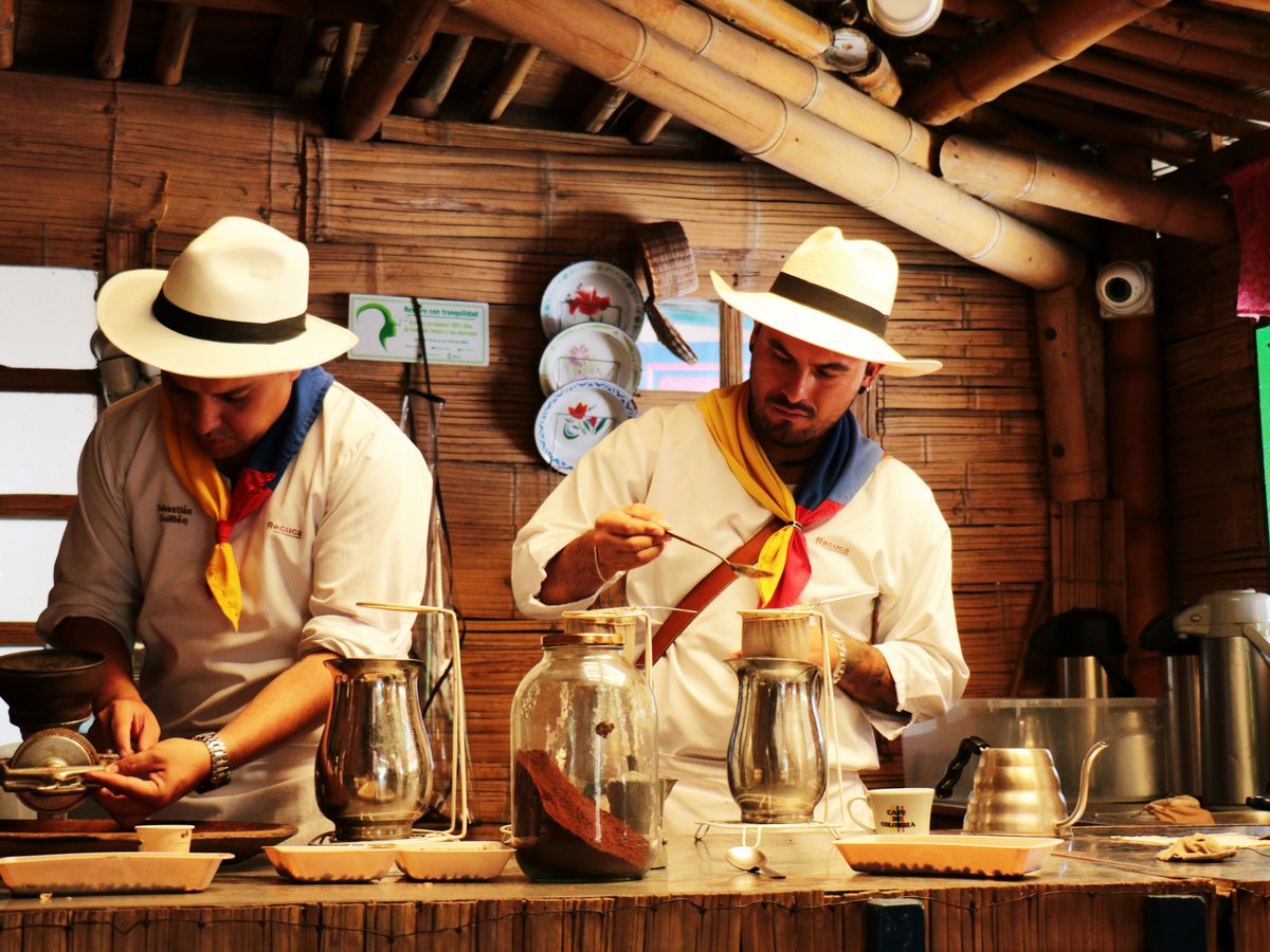 a couple of men standing in a kitchen preparing food