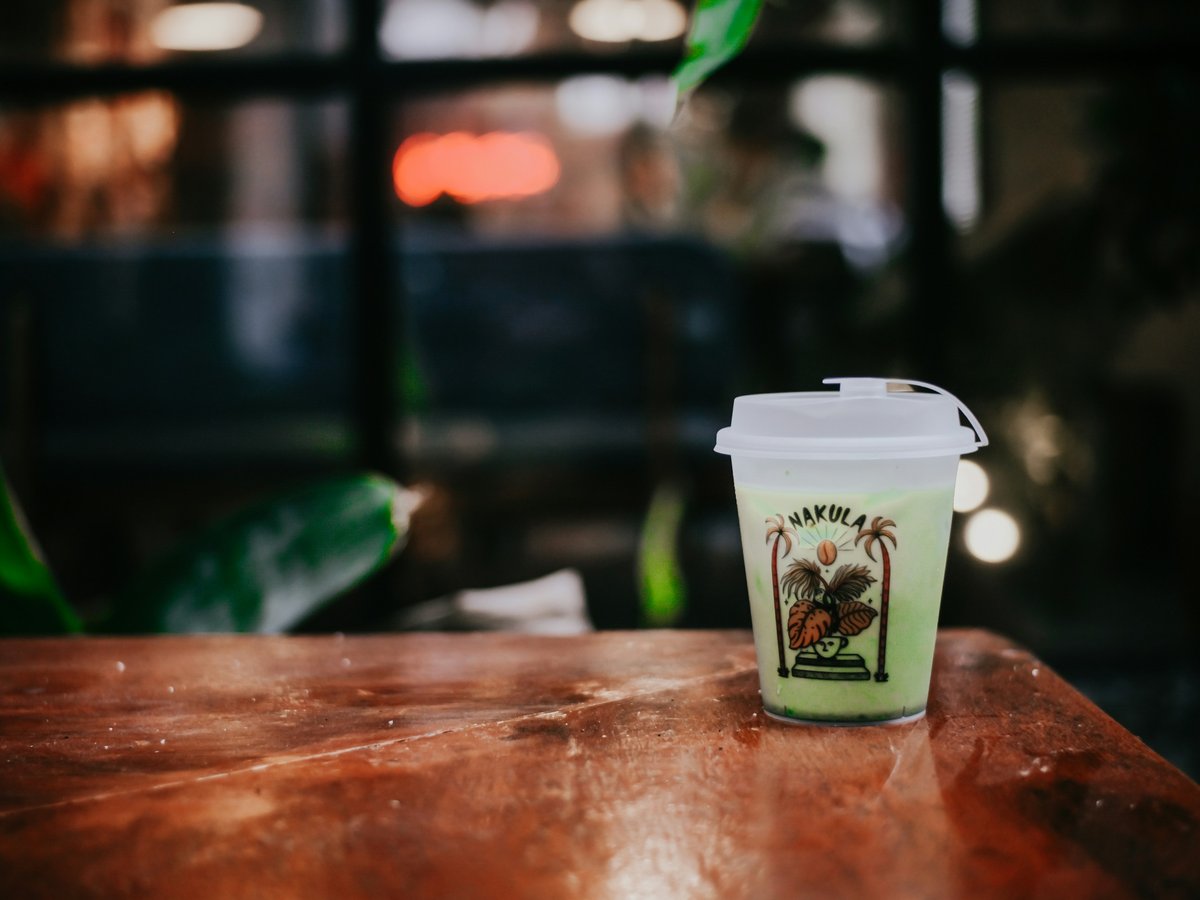 a cup of coffee sitting on top of a wooden table
