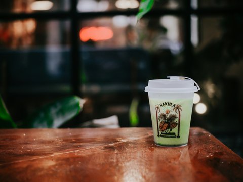 a cup of coffee sitting on top of a wooden table