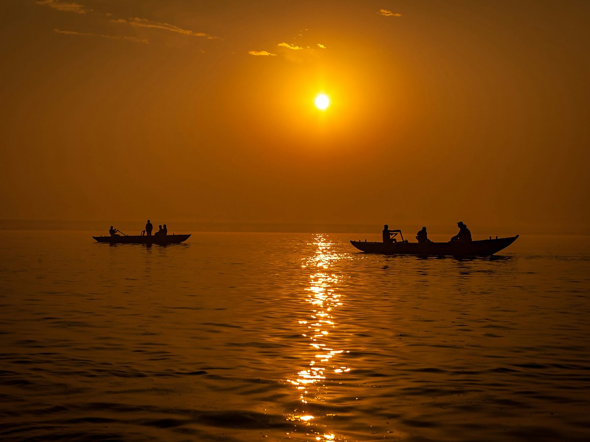 silhouette of people riding on boat during sunset
