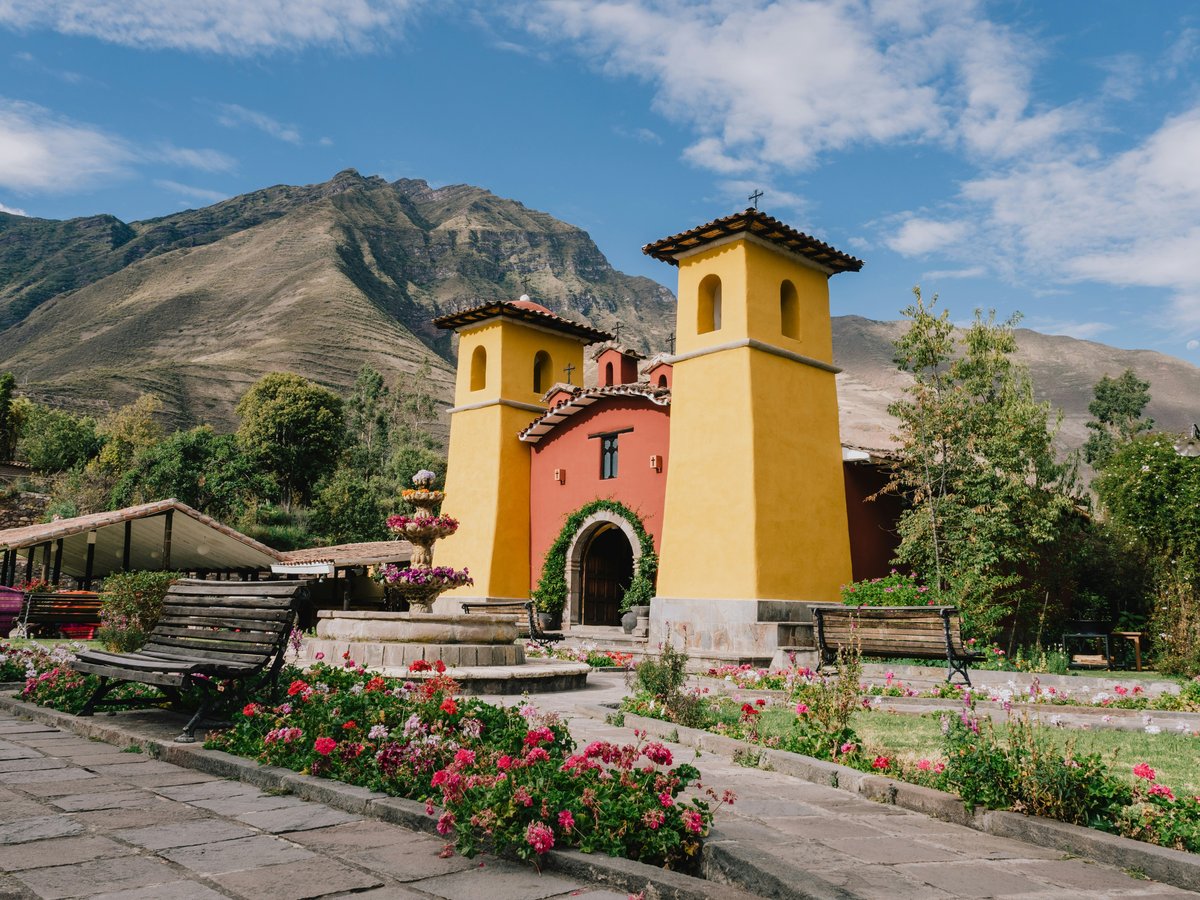 a yellow and red building surrounded by flowers