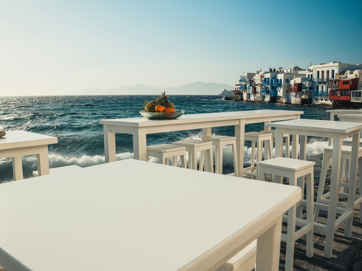 A white table and chairs sitting on the beach